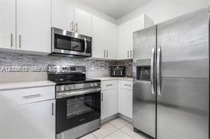 2781 Northwest 55th Way Lauderhill, FL 33313 - Photo 3 of 12 a kitchen with stainless steel appliances granite countertop a stove a refrigerator and a microwave