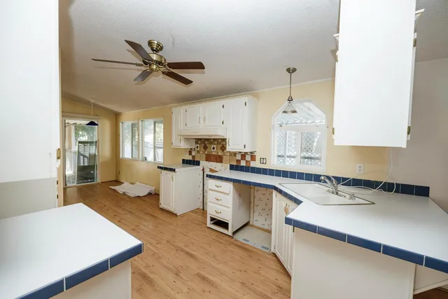 a kitchen with a sink cabinets and wooden floor