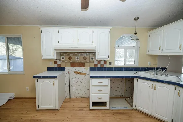 a kitchen with granite countertop a sink stainless steel appliances and cabinets