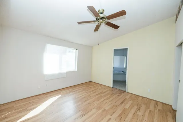 a view of a big room with wooden floor and windows