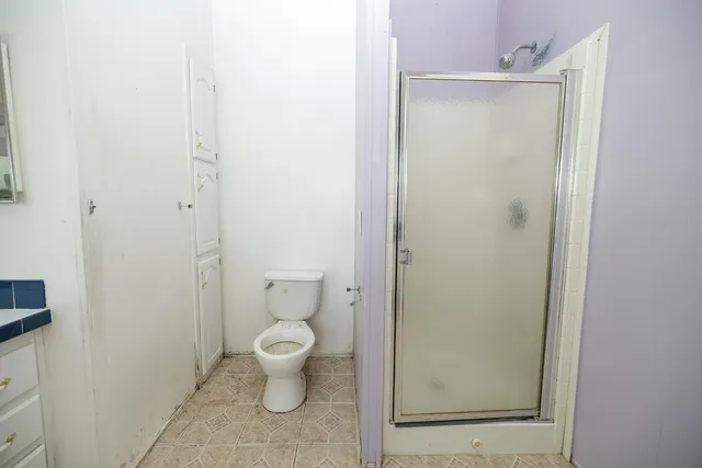 a bathroom with a granite countertop toilet and a sink