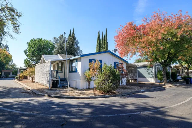a front view of house with yard and trees around
