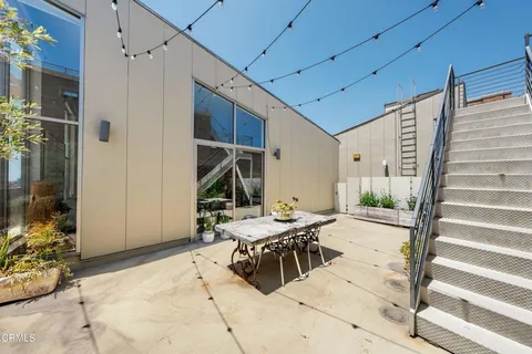 a view of a patio with table and chairs with wooden floor and fence
