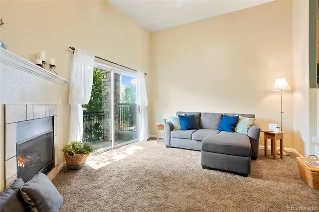 a living room with furniture a large window and a fireplace