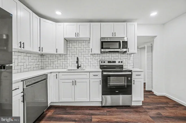 a kitchen with cabinets stainless steel appliances and sink