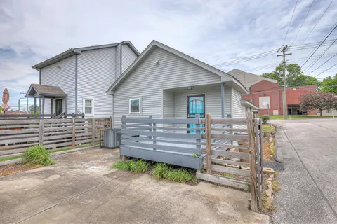 a view of a house with a yard and wooden fence