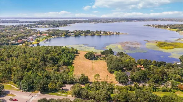 an aerial view of a city with lots of residential buildings ocean and mountain view in back
