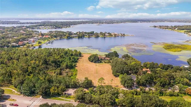 an aerial view of a city with lots of residential buildings ocean and mountain view in back
