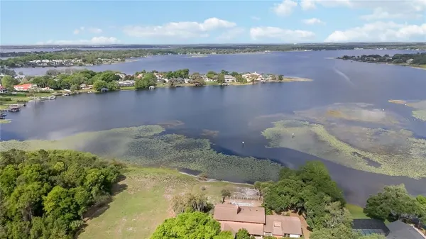 an aerial view of residential houses with outdoor space and lake view