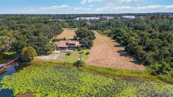 a aerial view of a house with a yard and lake view