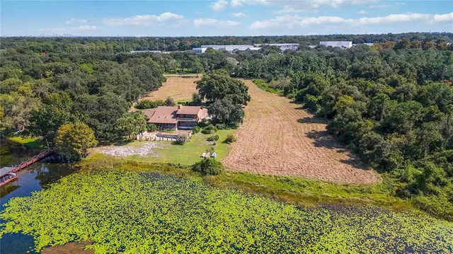 a aerial view of a house with a yard and lake view