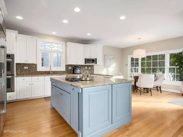 a kitchen with stainless steel appliances granite countertop sink stove top oven and cabinets