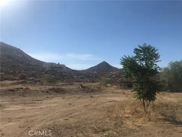 a view of a dry yard with mountains in the background