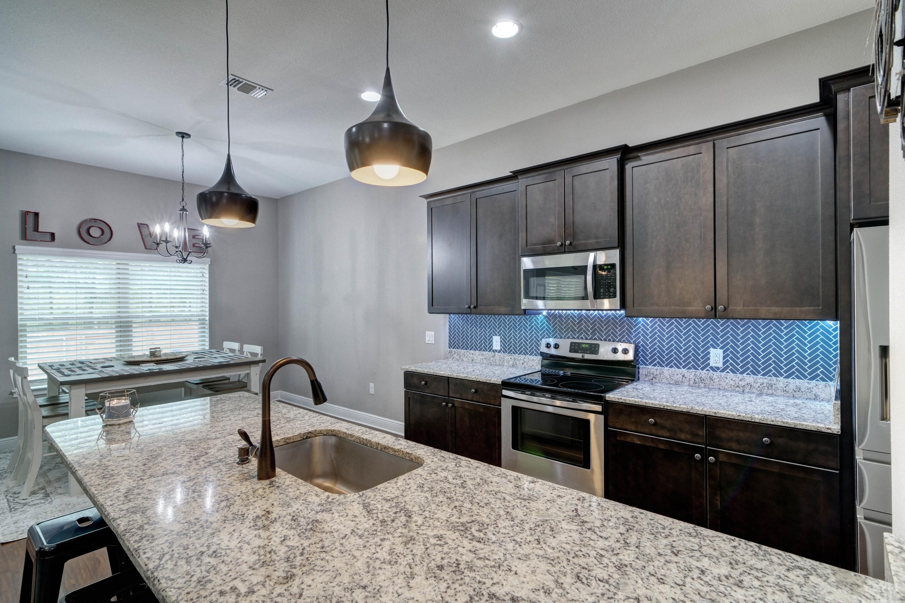 3083 5 Forks Road Navarre, FL 32566 - Photo 13 of 57 a kitchen with granite countertop a sink stainless steel appliances and cabinets