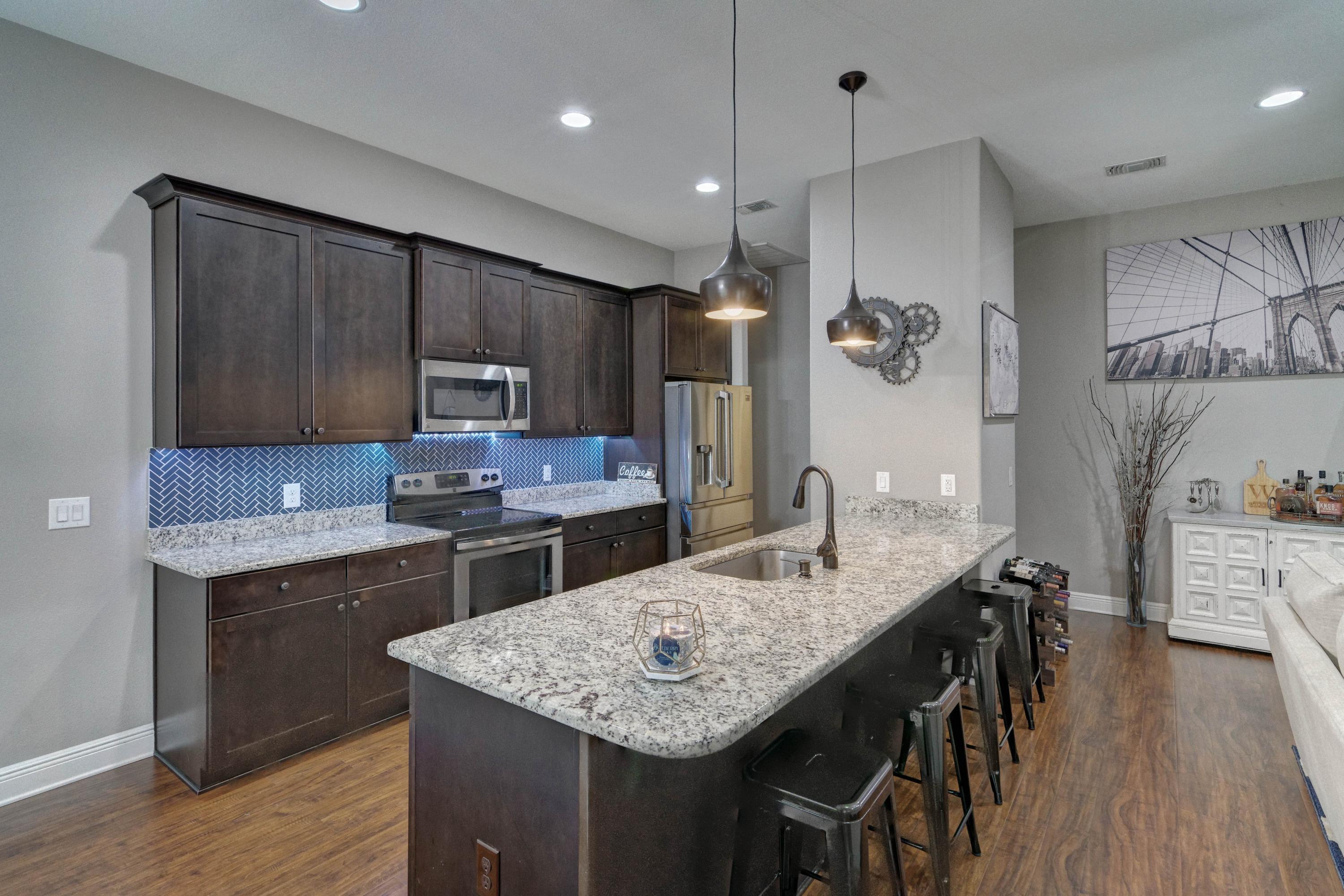 3083 5 Forks Road Navarre, FL 32566 - Photo 14 of 57 a kitchen with kitchen island a wooden floor and white cabinets