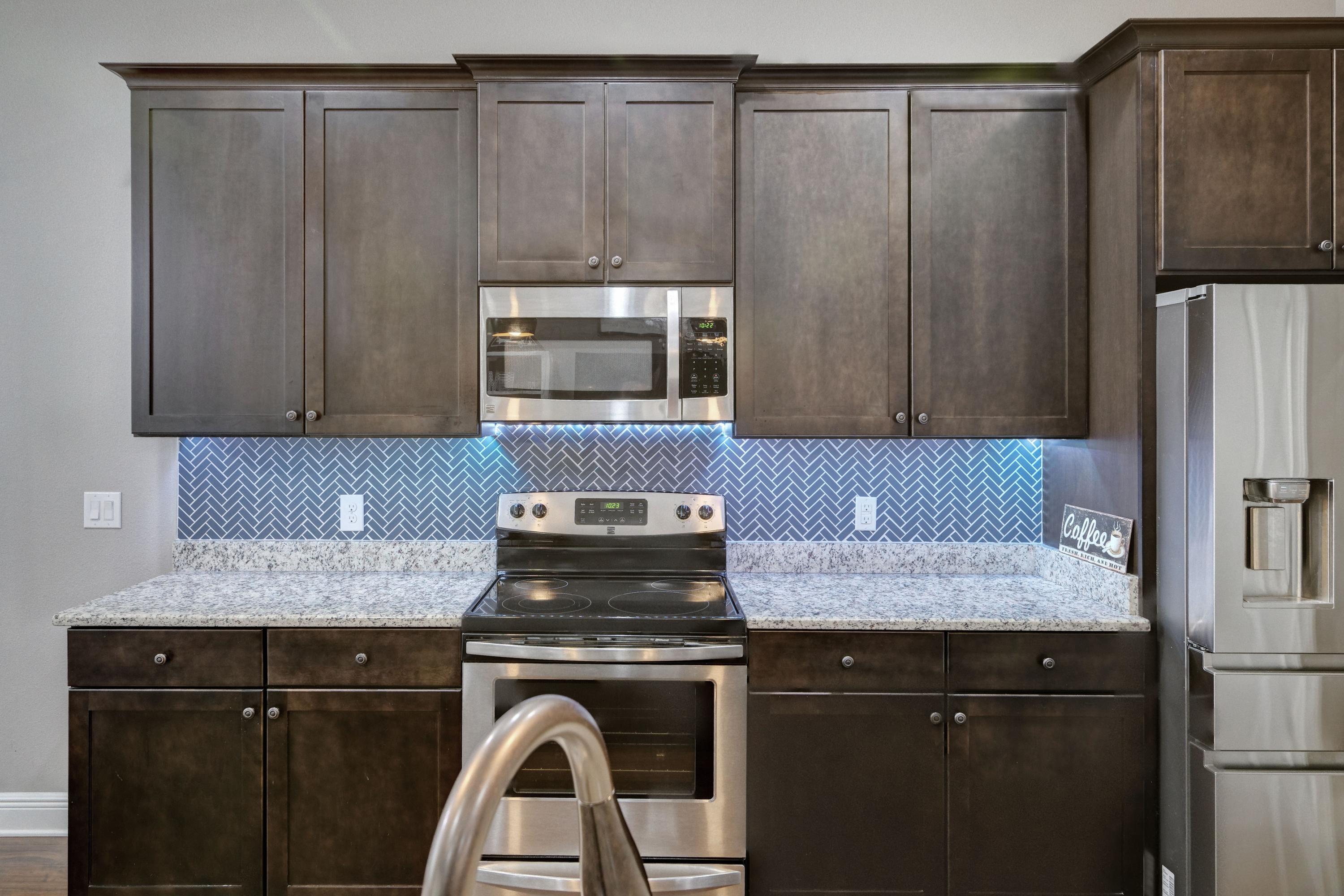 3083 5 Forks Road Navarre, FL 32566 - Photo 19 of 57 a kitchen with granite countertop a refrigerator stove and microwave