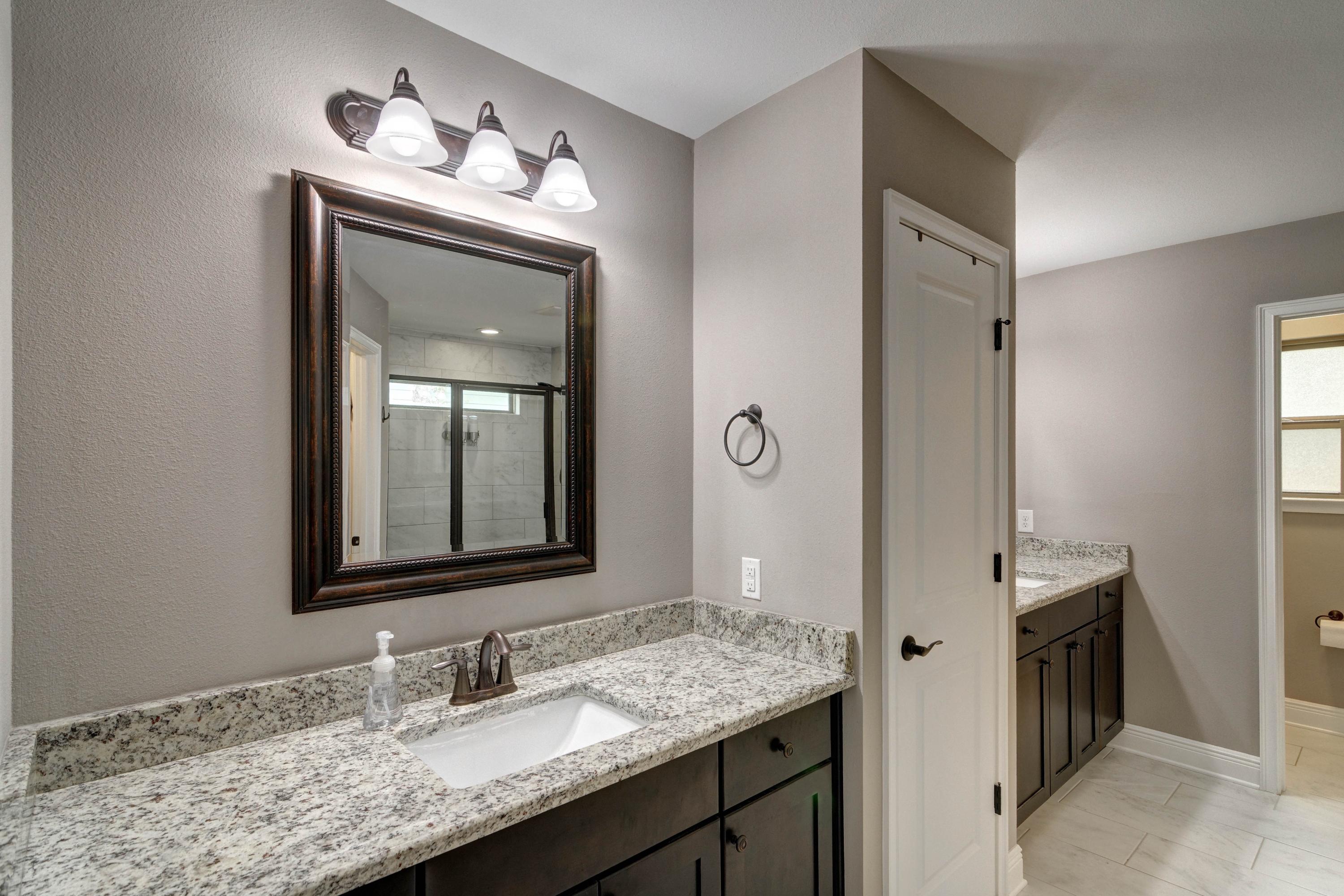 3083 5 Forks Road Navarre, FL 32566 - Photo 26 of 57 a bathroom with a granite countertop sink a mirror and a vanity
