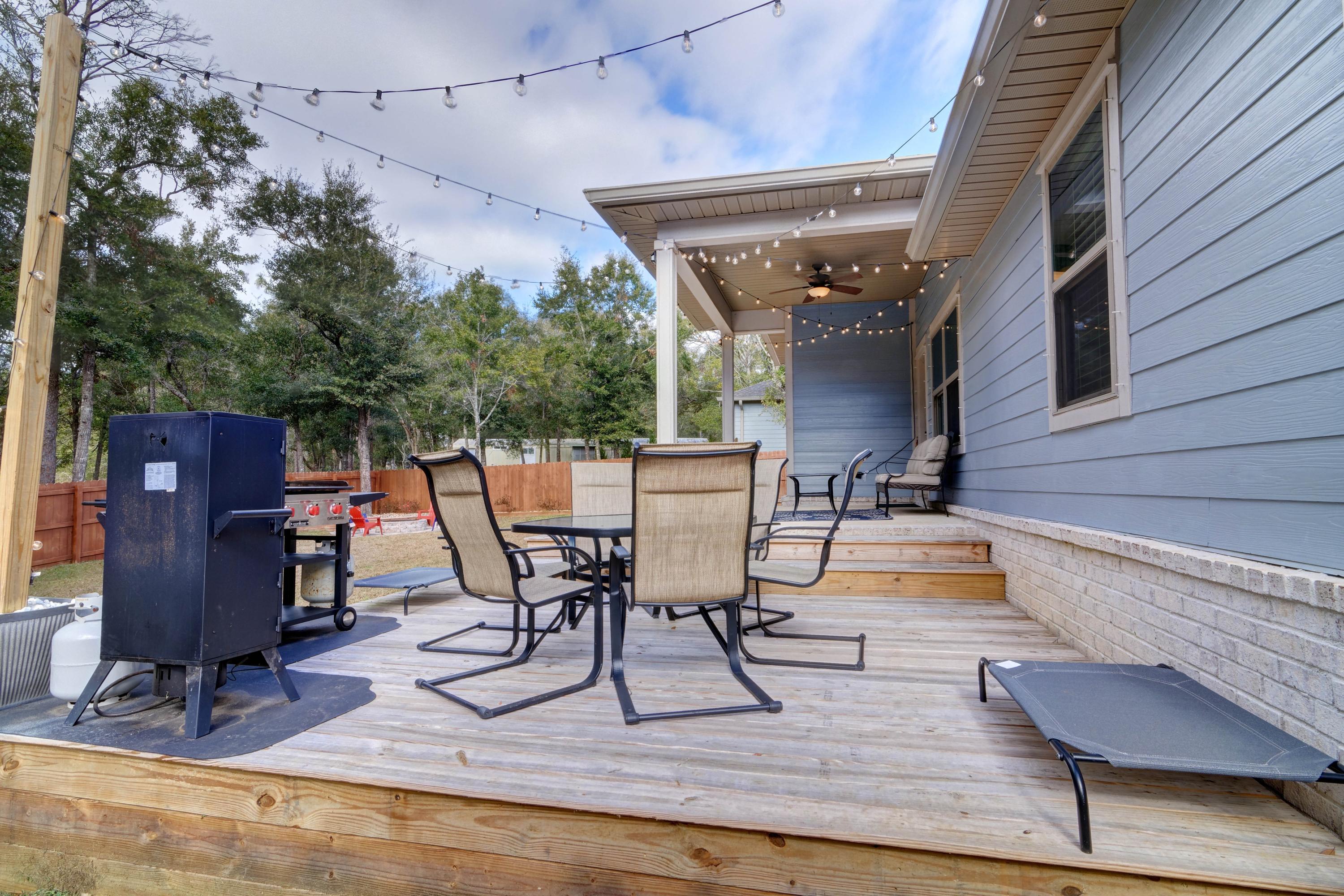 3083 5 Forks Road Navarre, FL 32566 - Photo 46 of 57 a view of a patio with table and chairs with wooden floor and fence