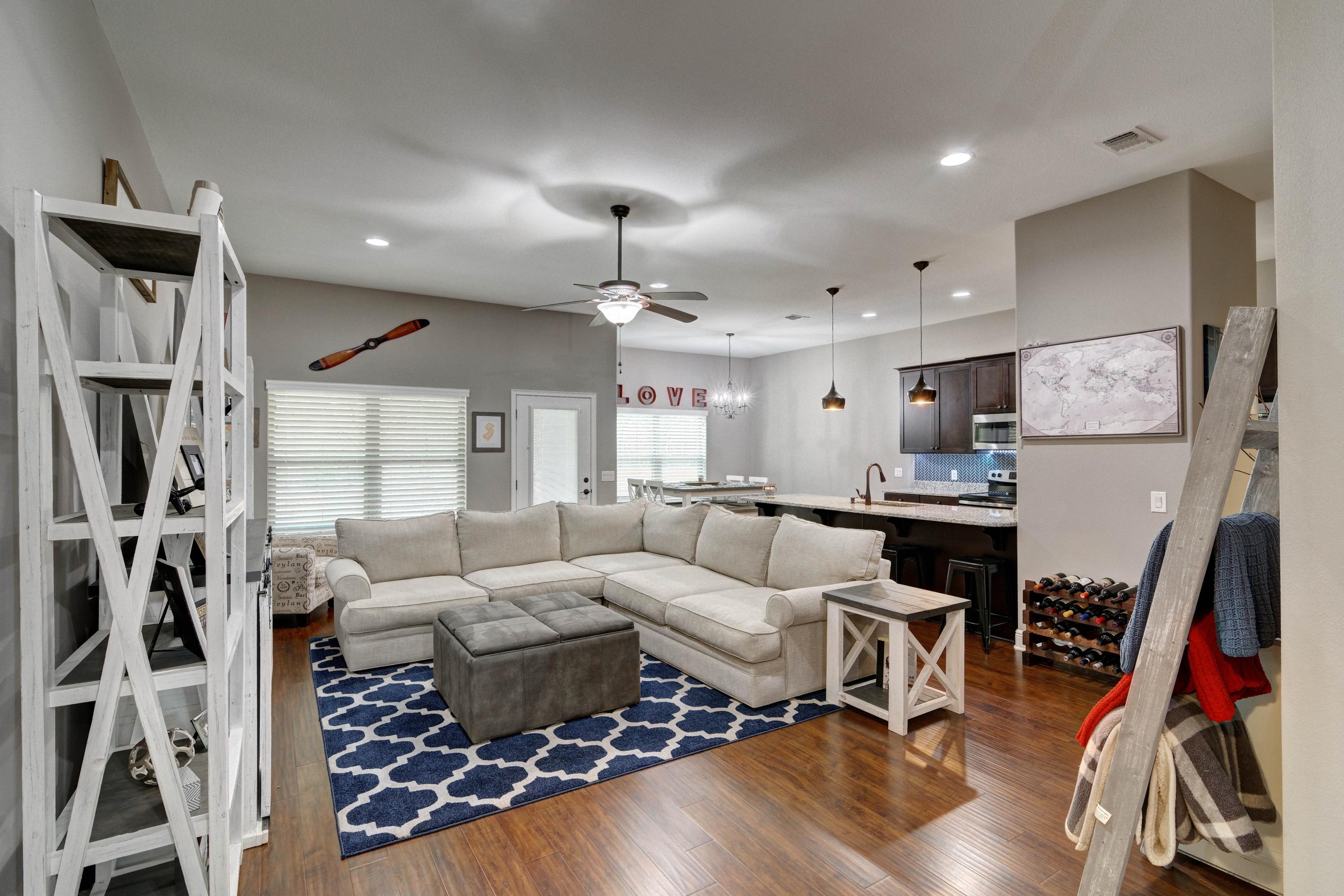 3083 5 Forks Road Navarre, FL 32566 - Photo 7 of 57 a living room with furniture a rug and gym equipment