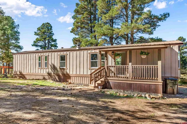 a view of a house with a small yard and wooden fence