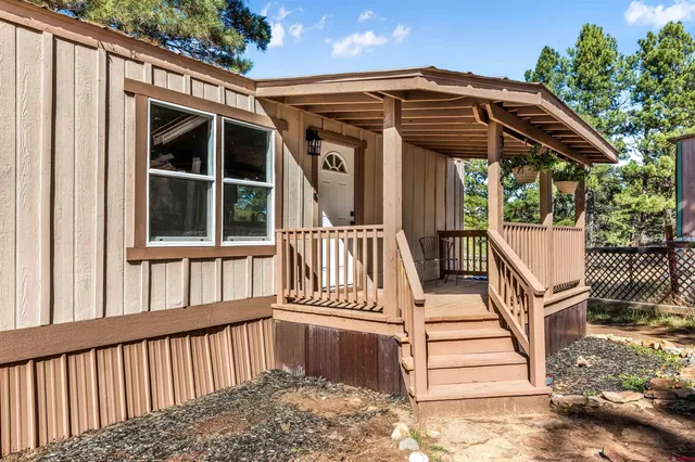 a view of wooden house with a small deck