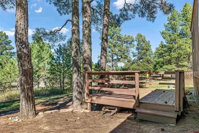 a view of a wooden bench next to a yard