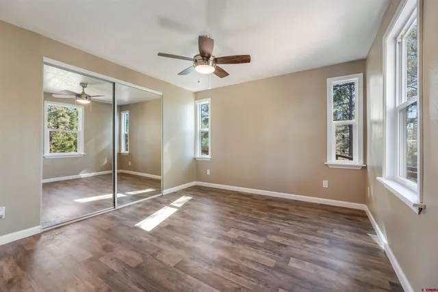a view of an empty room with window and wooden floor