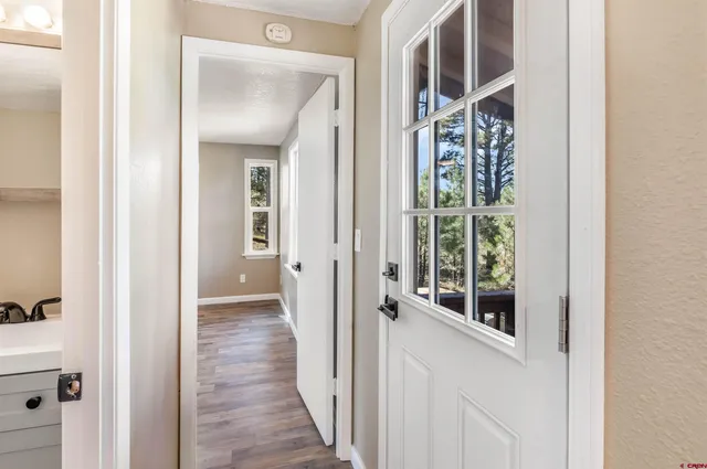 a view of a hallway with wooden floor and entryway