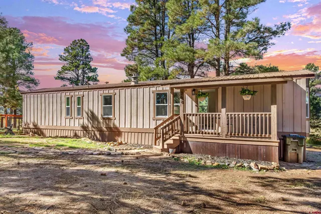 a view of a house with a small yard and wooden fence