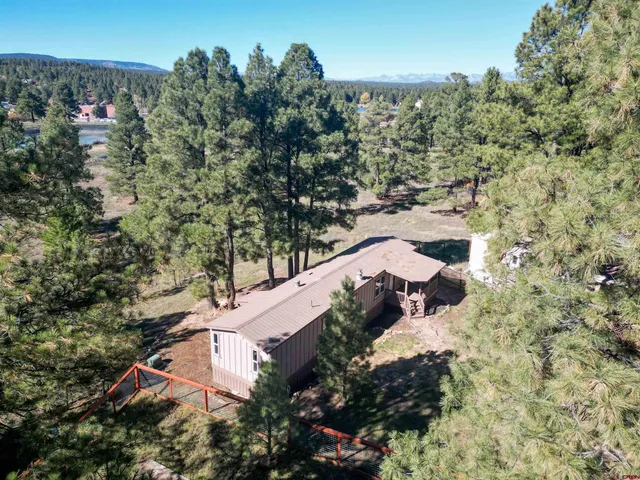 an aerial view of house with yard and mountain view in back