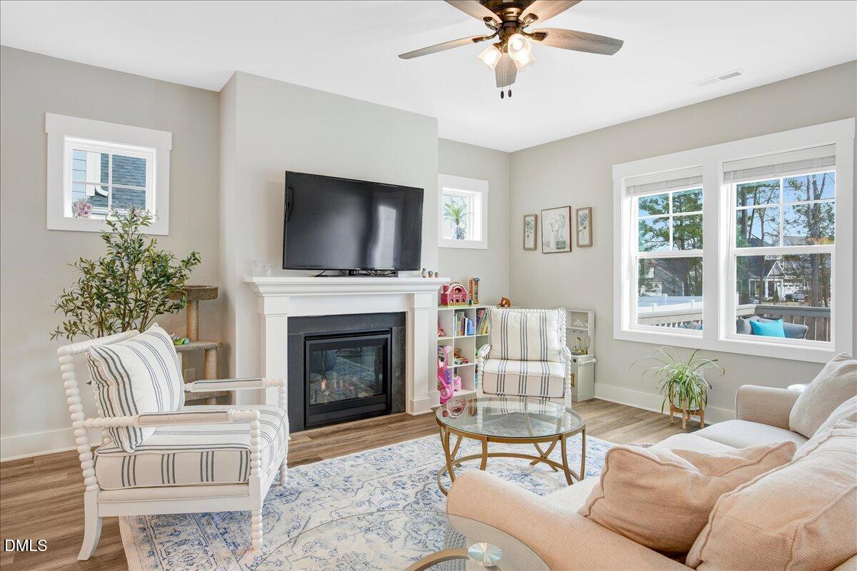 1105 Logperch Way Wendell, NC 27591 - Photo 3 of 29 a living room with furniture a flat screen tv and a fireplace