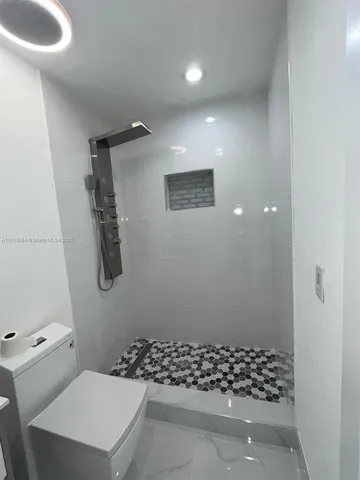 a bathroom with a toilet and a shower