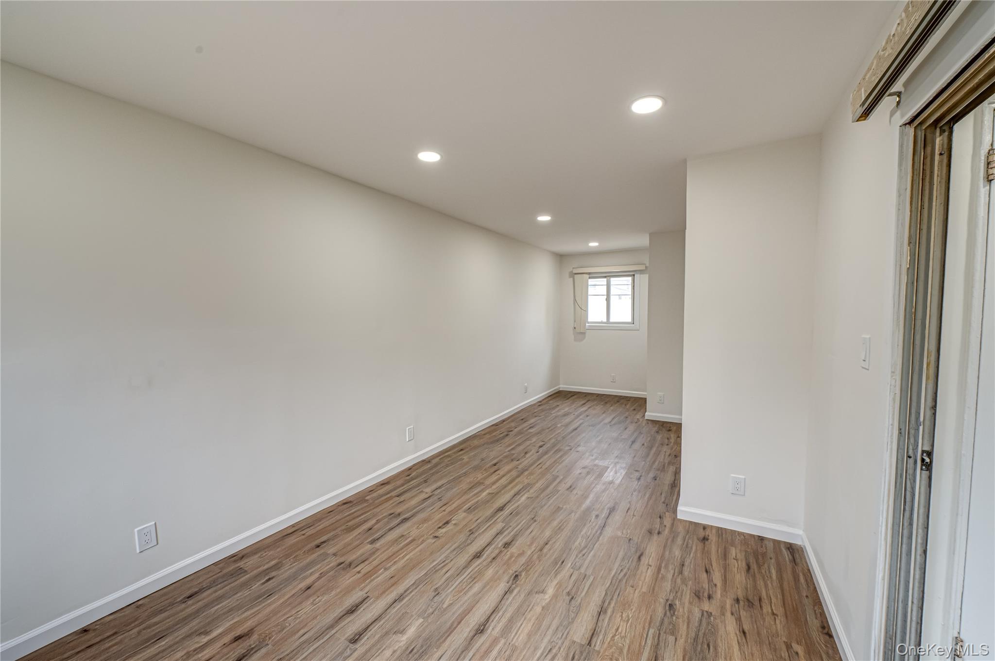 10 Gerhard Road Plainview, NY 11803 - Photo 5 of 13 a view of wooden floor and windows in an empty room