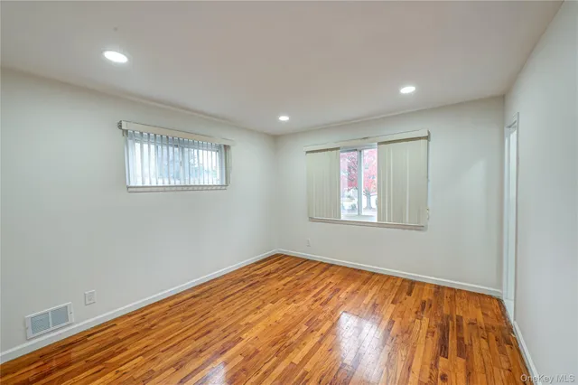 a view of empty room with wooden floor