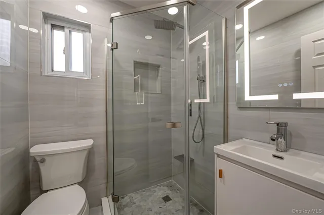 a bathroom with a toilet sink shower and mirror