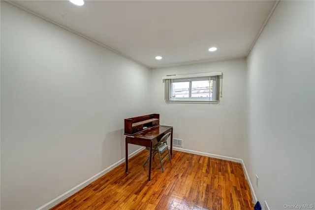 a view of a room with wooden floor and a window