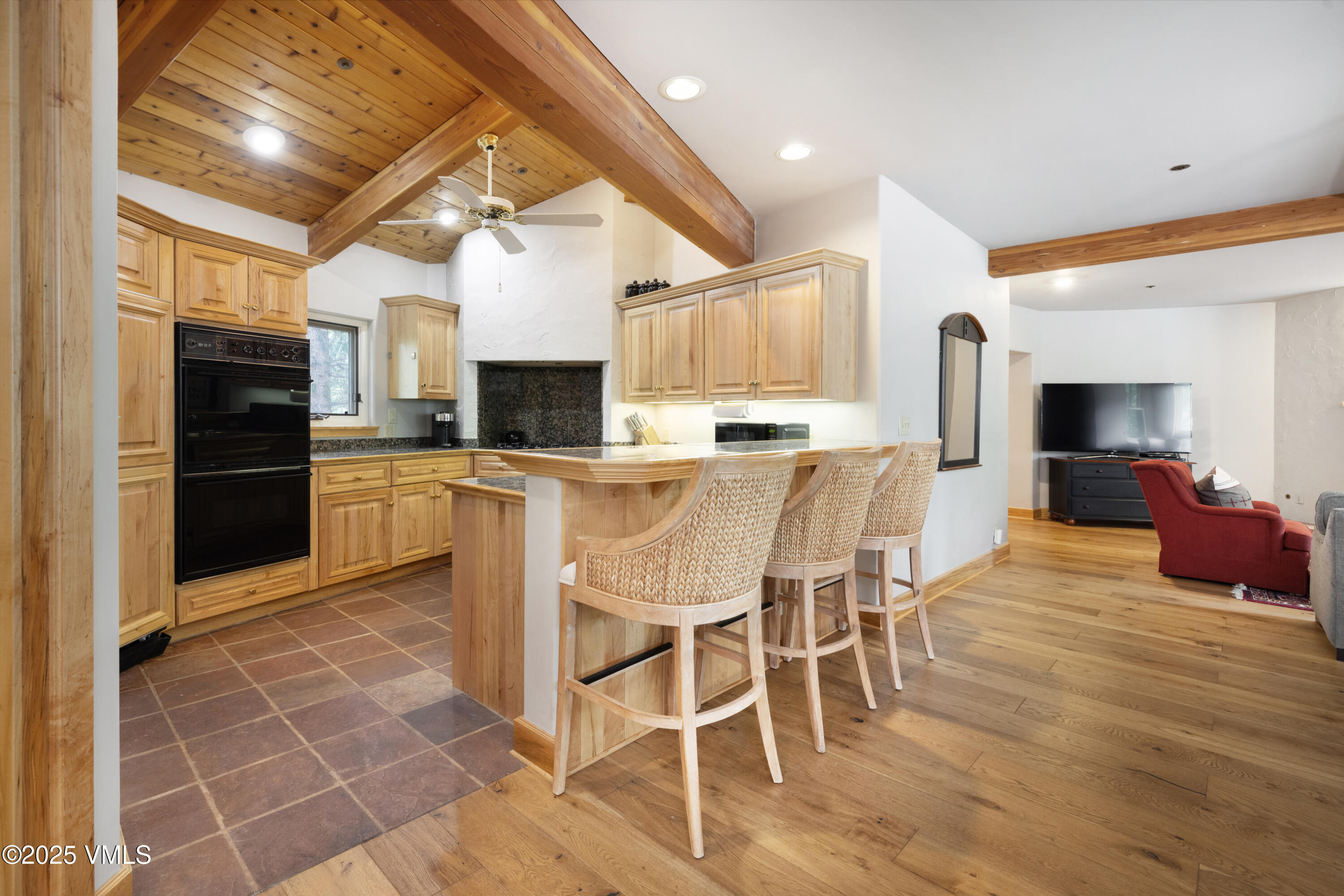 66 Arrowhead Circle, Unit 13 Edwards, CO 81632 - Photo 4 of 12 a kitchen with stainless steel appliances kitchen island granite countertop a stove top oven a sink dishwasher a dining table and chairs with wooden floor