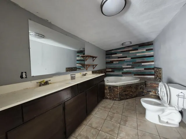 a bathroom with a double vanity sink mirror and toilet