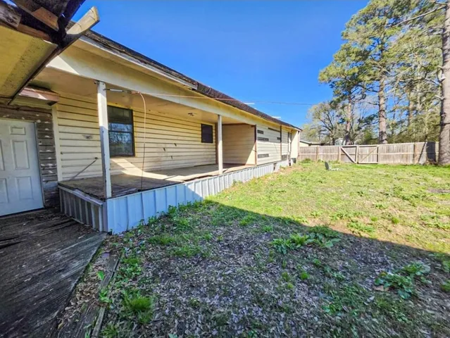 a view of a backyard with wooden fence