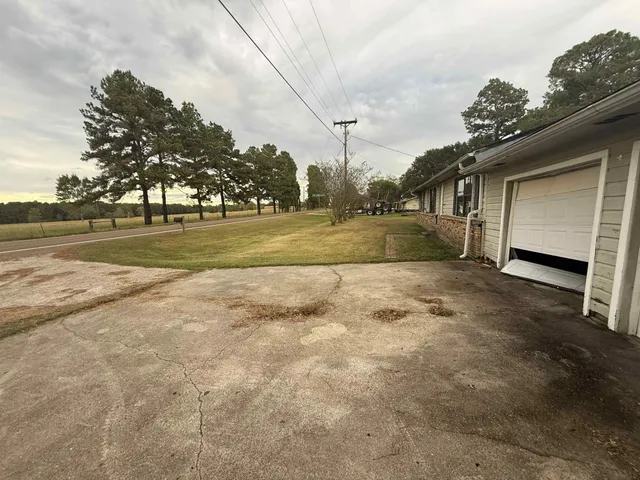 a view of backyard of house with green space