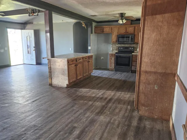 a kitchen with stainless steel appliances granite countertop a refrigerator a stove and a sink