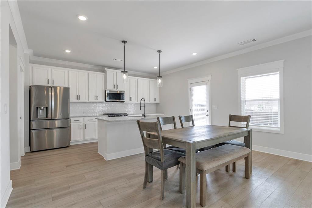 5316 Milford Road Gainesville, GA 30507 - Photo 17 of 44 a kitchen with refrigerator a stove a dining table and chairs