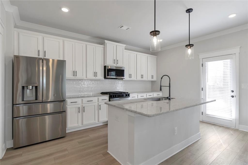 5316 Milford Road Gainesville, GA 30507 - Photo 18 of 44 a kitchen with stainless steel appliances granite countertop a refrigerator a sink dishwasher a stove and white cabinets with wooden floor