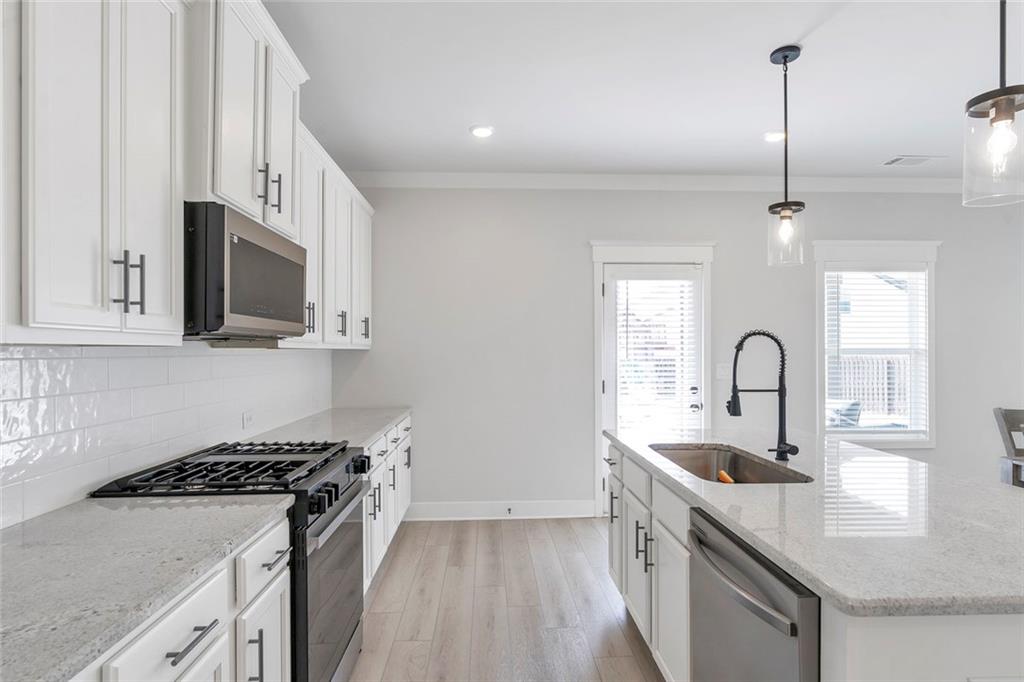 5316 Milford Road Gainesville, GA 30507 - Photo 19 of 44 a kitchen with kitchen island a sink stove top oven and microwave