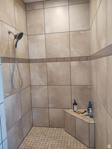 2170 Highway 357 Beaver, UT 84713 - Photo 30 of 56 Walk-in shower with large-format wall tiling, a decorative tile accent band, a built-in corner bench, and mosaic tile flooring