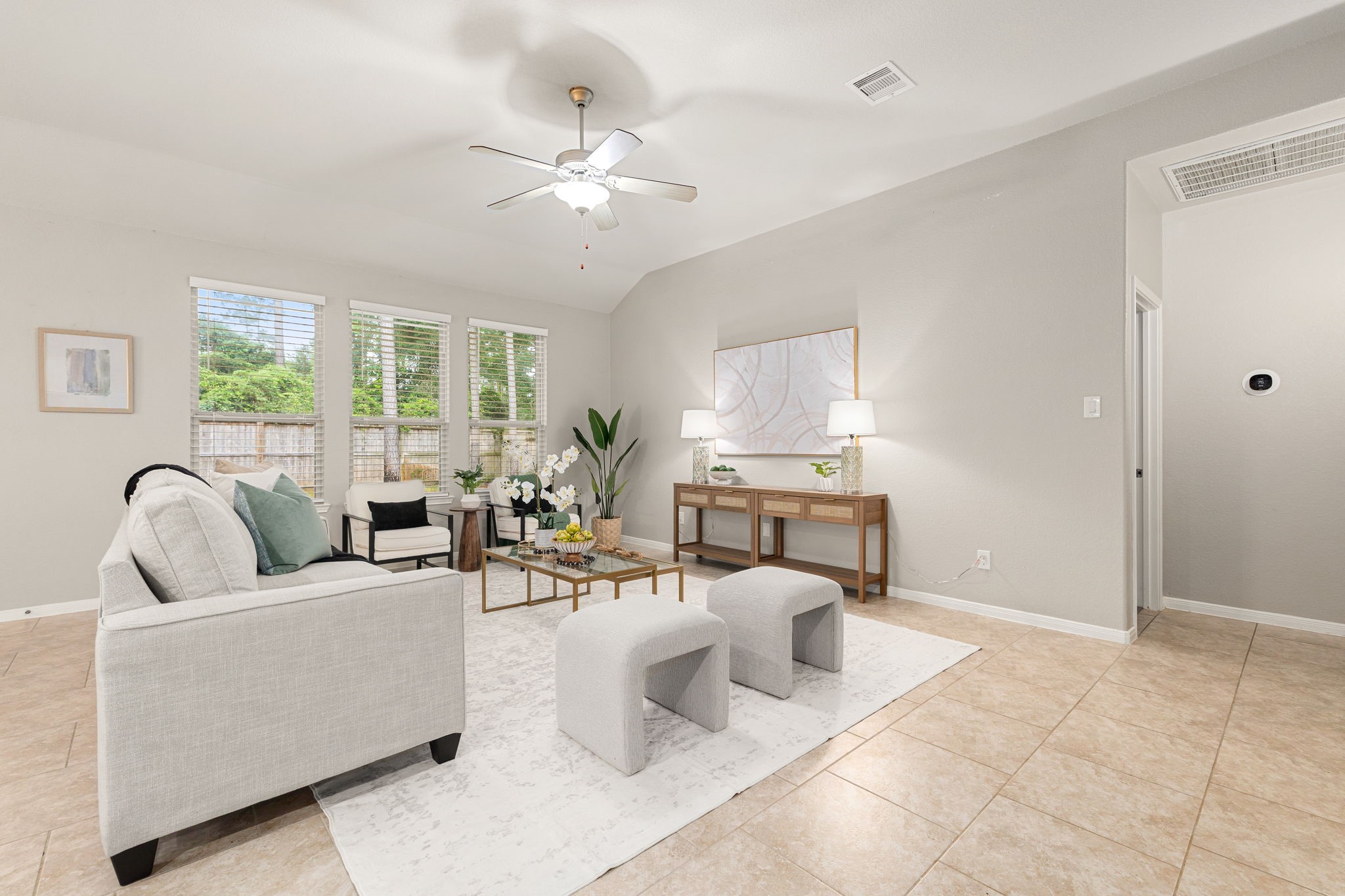 14023 Beaverhead Range Court Conroe, TX 77384 - Photo 6 of 30 This bright and airy living room features tile flooring, neutral toned walls, vaulted ceilings with ceiling fan, and large windows with fitted blinds allowing abundant natural lighting and gorgeous outdoor views.