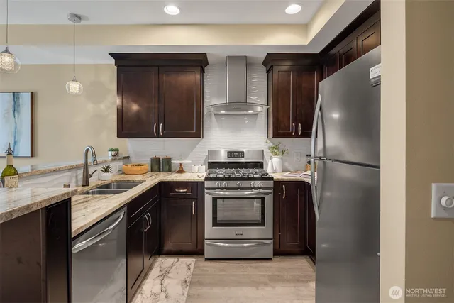 a kitchen with stainless steel appliances granite countertop a sink stove and refrigerator