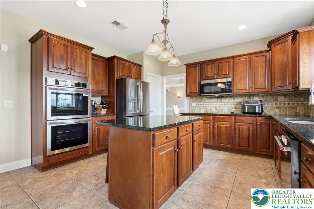 245 East Dell Road Bath, PA 18014 - Photo 14 of 99 A well-appointed kitchen showcasing rich cabinetry and dark granite countertops.