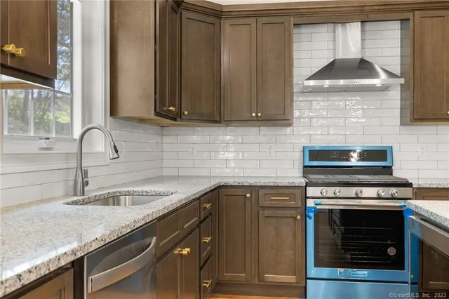 a kitchen with granite countertop a sink stainless steel appliances and cabinets