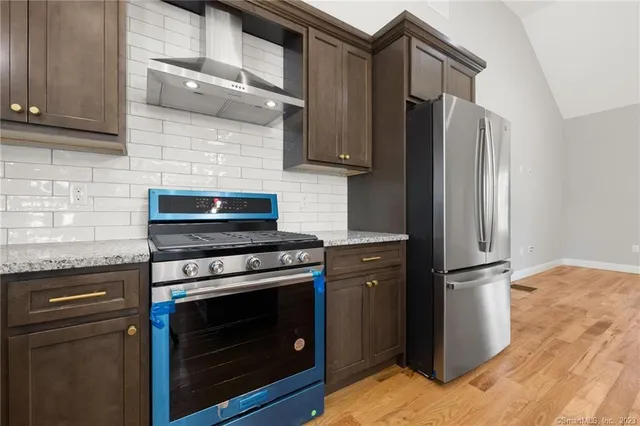 a kitchen with stainless steel appliances granite countertop a refrigerator stove and sink